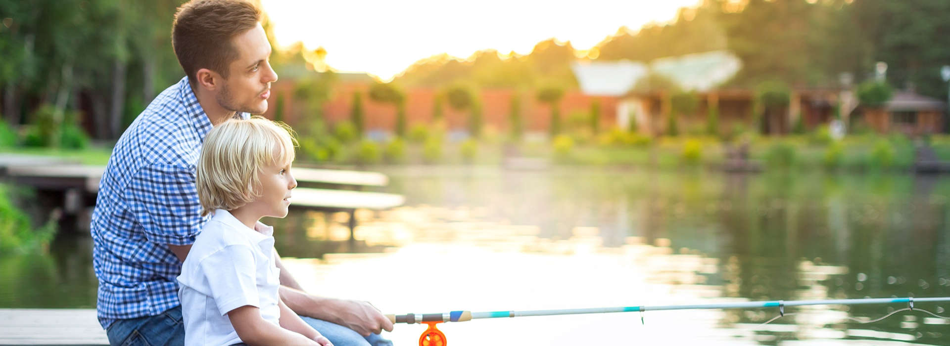 father and his son fishing on a lake