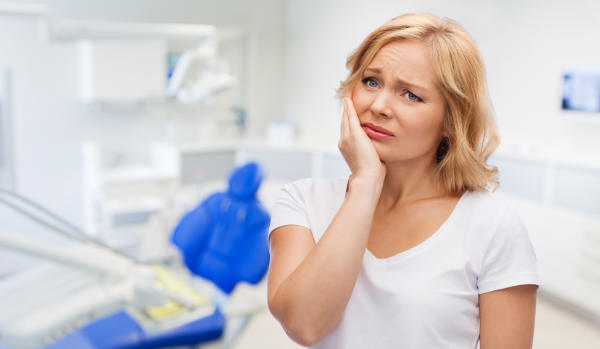 a woman suffering from tooth pain in a dental office