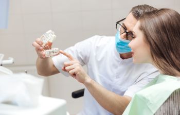 A dentist explaining restorative options to a female patient