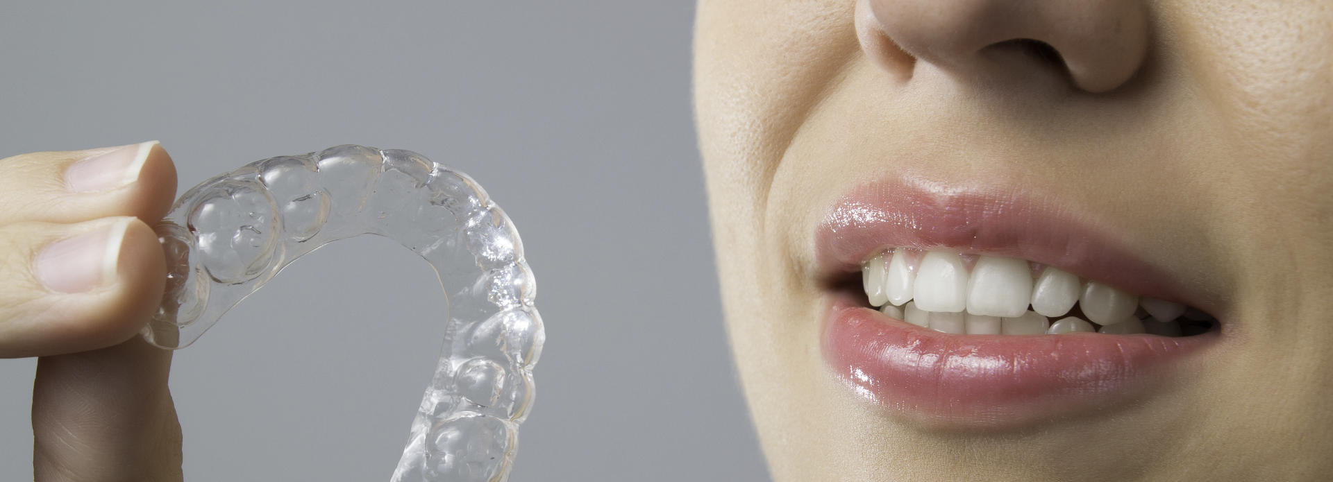 woman holding clear aligner