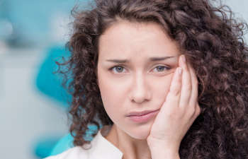 A woman with a toothache in a dentist's office.