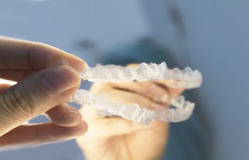 A person holding a set of clear braces.