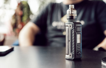 vape stands on a wooden table in cafe