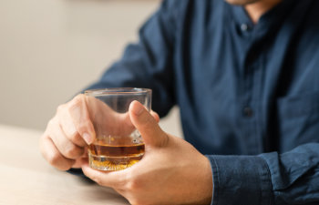male hand holding a glass of alcohol