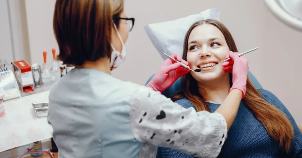 Dentist examining patient teeth with tools during dental checkup
