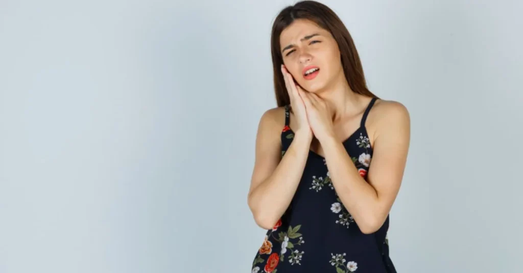 Young woman holding jaw due to teeth whitening and tooth sensitivity pain